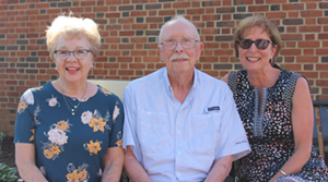 Ginna and Bob Mashburn, along with Bob’s daughter Missy Parker, take a seat on the new bench installed in the garden.