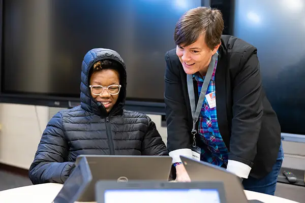 An instructor in the writing center talks to a student