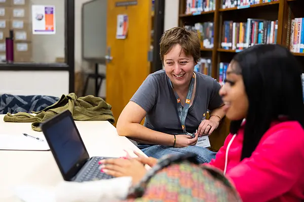 An instructor in the writing center talks to a student