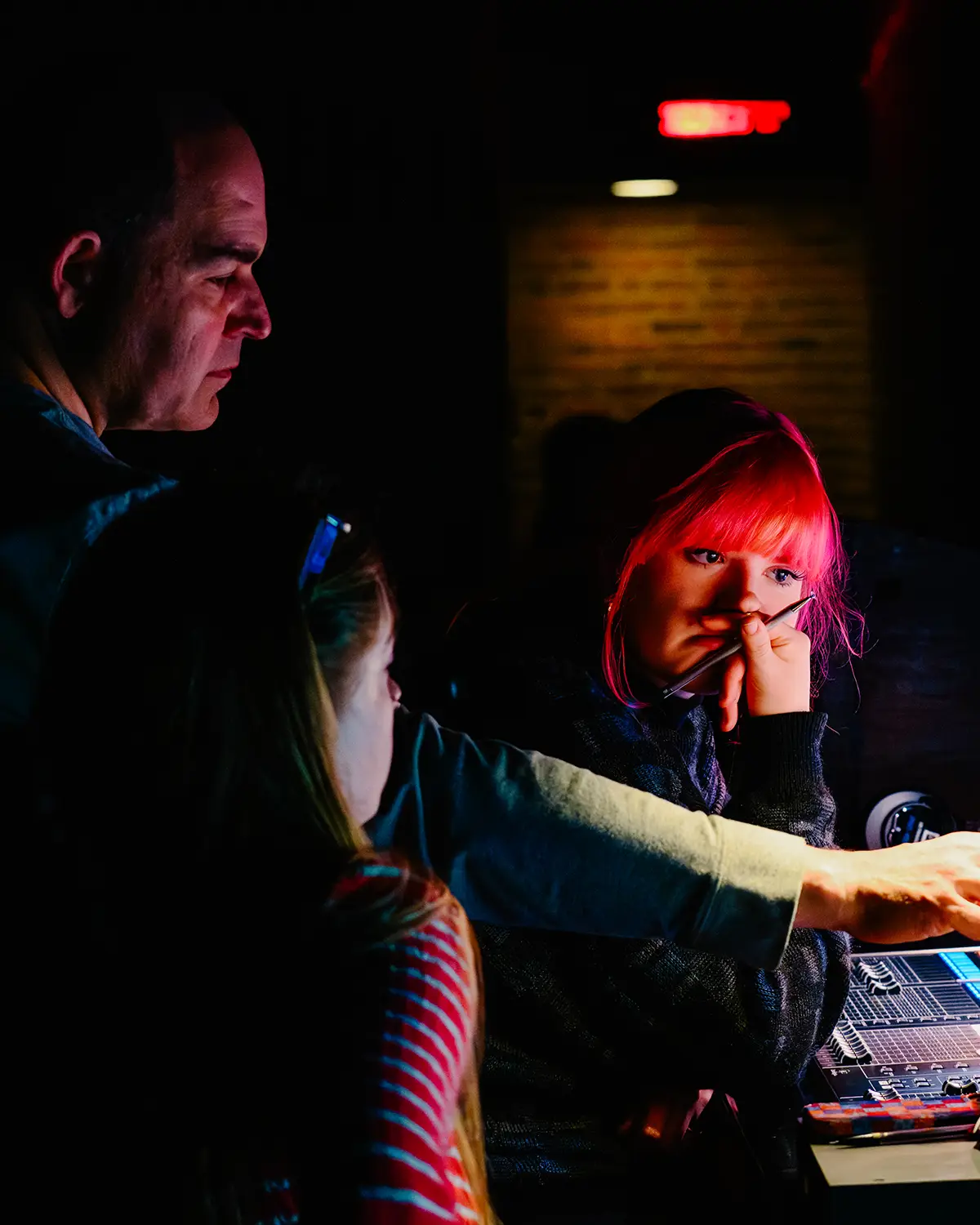 Three crew members in discussion and looking at a screen