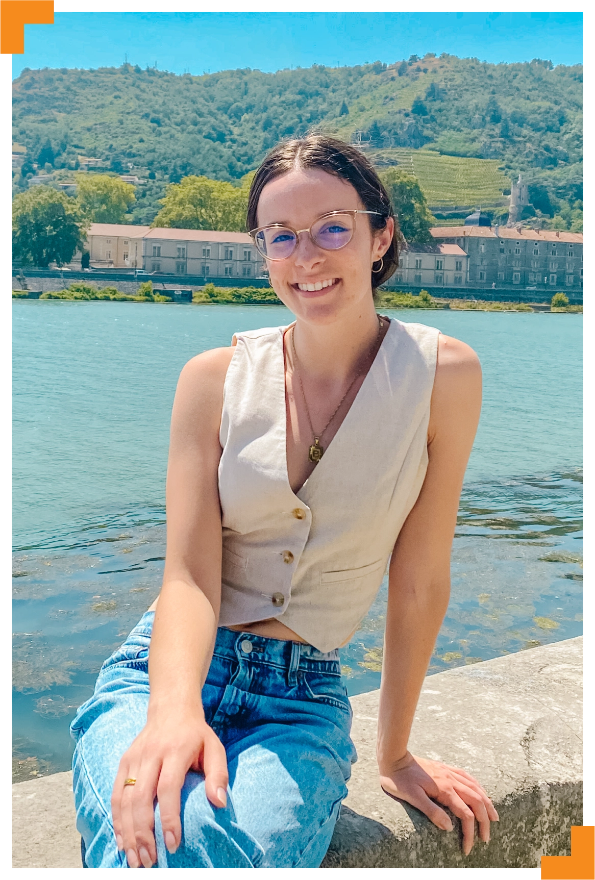 A photo of a young woman with water behind her