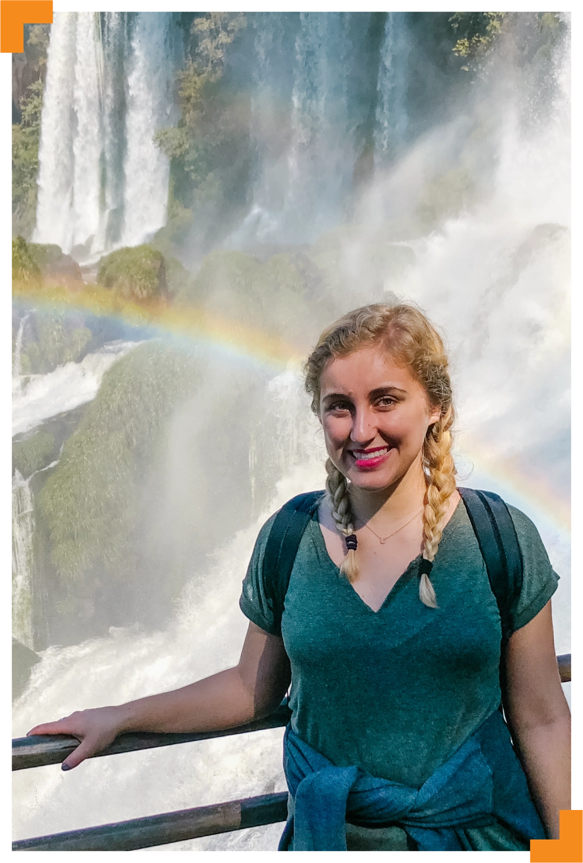 A photo of a young woman wearing a backpack with a waterfall and rainbow behind her